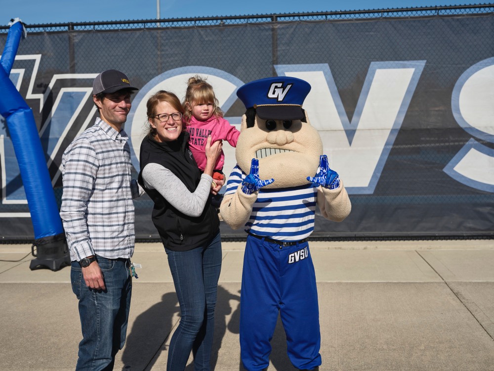 Dad, mom, and daughter smile with Louie